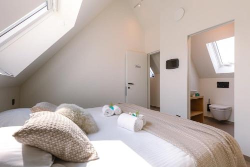 um quarto branco com uma cama com almofadas e uma janela em Tosca - Charming double room at ranch "De Blauwe Zaal" em Bruges