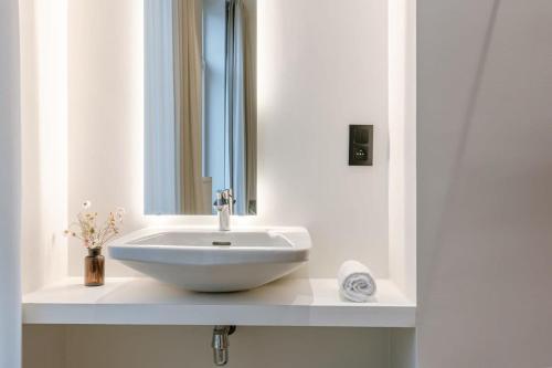 La salle de bains est pourvue d'un lavabo blanc et d'un miroir. dans l'établissement WAY SWEET DREAMS - Room 1, à Gand