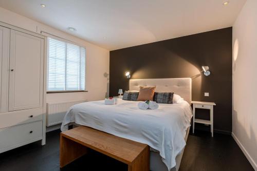Un dormitorio con una gran cama blanca y una ventana en Delicious house for 8 persons with sunny-garden in Duinbergen en Knokke-Heist