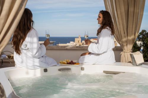two women sitting in a bath tub with a plate of food at Relais Valle Dell'Idro in Otranto