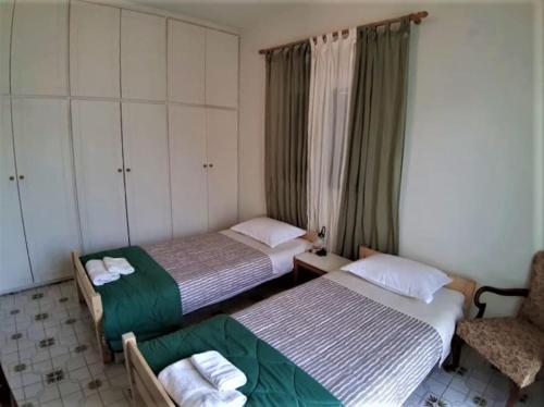 - 2 lits dans une petite chambre avec une chaise et un lit dans l'établissement Castello House, à Patras