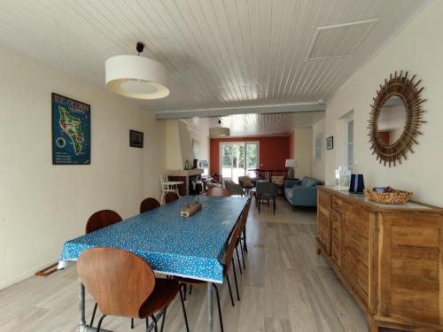 une salle à manger avec une table et des chaises bleues dans l'établissement A 80m de la plage de Plaisance pour 8 personnes, à Saint-Georges-dʼOléron