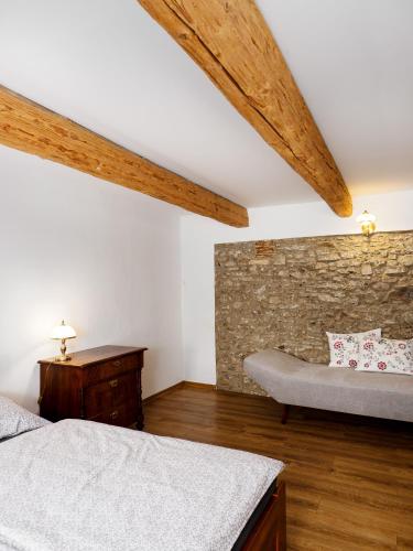 a bedroom with two beds and a stone wall at Płonica 1 in Złoty Stok
