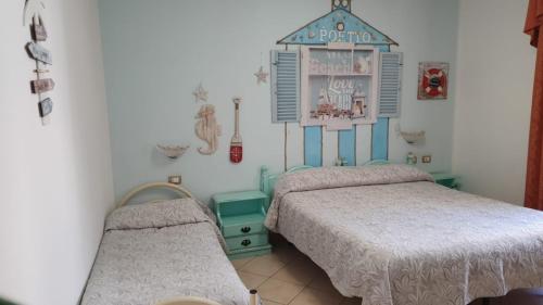 a bedroom with two beds and a sign on the wall at Hotel 4 Mori in Cagliari