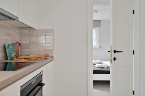 a kitchen with a counter and a bed in a room at Bright and spacious bungalow with garden near the beach in Middelkerke