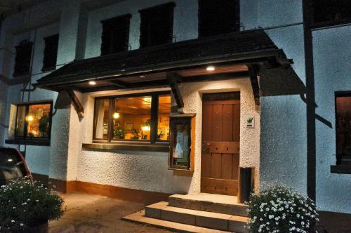 a building with a wooden door and windows at night at Alemannenhof Hotel Engel in Rickenbach