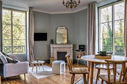 un salon avec une table et une cheminée dans l'établissement Logement Alice Wilson, à Mont-sous-Vaudrey