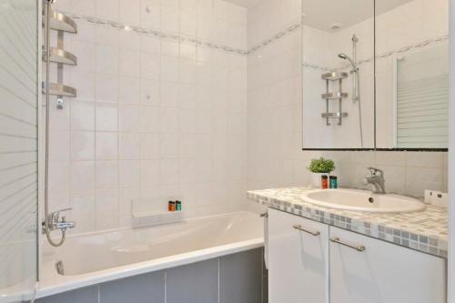 a white bathroom with a tub and a sink at Charming house in the beautiful village Donk with a terrace in Maldegem
