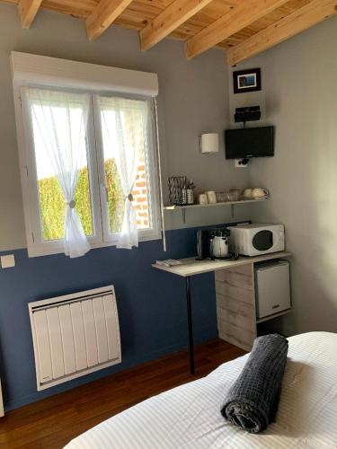 une chambre avec un lit, une table et une fenêtre dans l'établissement Le clos des 3 pins, à Froberville