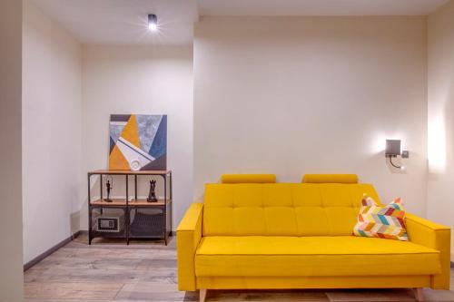 a yellow couch in a living room with a table at Hotel Forty One in Bucharest