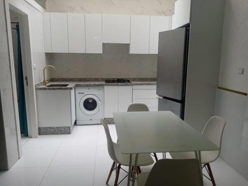 een keuken met een tafel en een wasmachine bij super appartment in tetouan in Martil