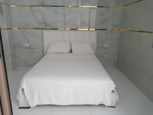 een wit bed met 2 kussens in een kamer bij super appartment in tetouan in Martil