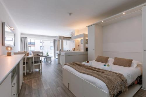 1 dormitorio con 1 cama grande y cocina en Warm studio with sea view and view on the new casino, en Middelkerke