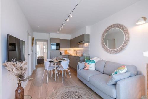 克诺克－海斯特Huswell - Stunning Seafront Apartment的客厅里有一张蓝色的沙发和一张桌子