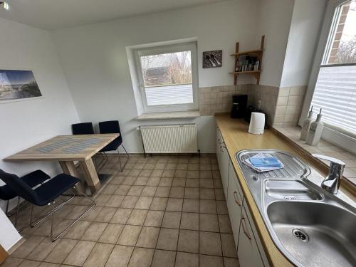 a kitchen with a sink and a table with chairs at Fehmarn 17-7 in Fehmarn