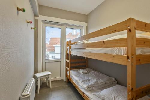 een slaapkamer met 2 stapelbedden en een raam bij Lovely Family Apartment 50 meters from the Sea in De Haan