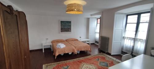 Una sala de estar con una cama y una mesa y ventanas. en PISO CON TERRAZA, en Ribadeo