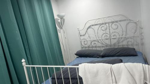 1 dormitorio con 1 cama con cortinas verdes en Ground Floor Unit Near Liverpool, en Mount Pritchard