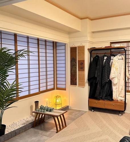 a room with a table and a rack of clothes at Kyo Sai 浅草3F　120㎡超え浅草寺まで徒步約10分 in Tokyo