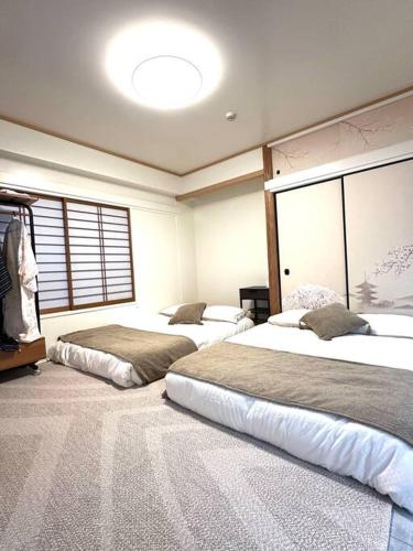 a bedroom with two beds and a large window at Kyo Sai 浅草3F　120㎡超え浅草寺まで徒步約10分 in Tokyo
