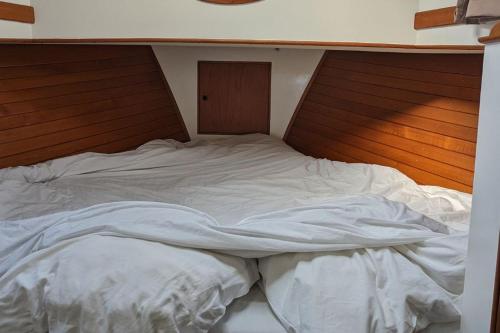 a large white bed with a wooden head board at Idéal Festival - Le Brise Iodée in Cannes