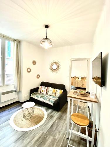un salon avec un canapé et une table dans l'établissement Appartement avec cinéma à 200m de la plage, à Nice