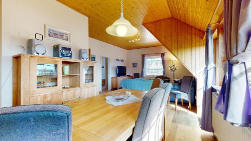 a dining room and living room with a table and chairs at Ferienhaus Möwe in Lancken-Granitz