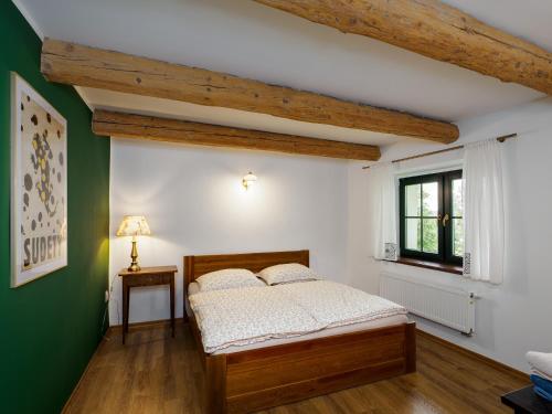 a bedroom with a bed and a green wall at Płonica 1 in Złoty Stok