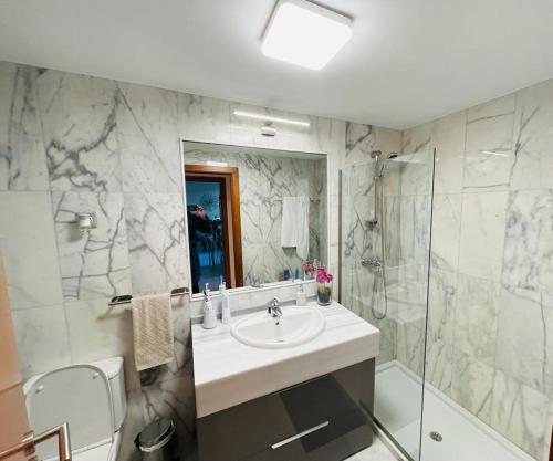 a bathroom with a sink and a shower at Parque Botanico Benahavis in Estepona
