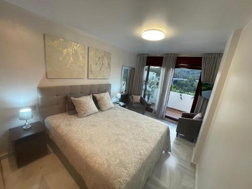 um quarto com uma cama e um quarto com uma janela em Parque Botanico Benahavis em Estepona