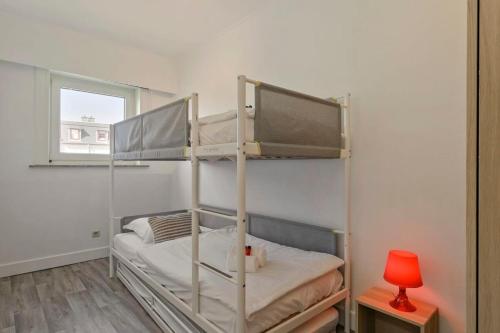 een slaapkamer met 2 stapelbedden en een rode lamp bij Charming apartment near the beach of Zeebrugge in Brugge