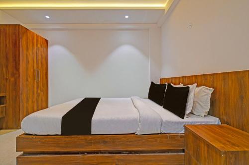 OYO Hotel Delight Stay في إندوري: غرفة نوم بسرير كبير مع اللوح الخشبي
