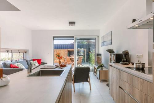een keuken en een woonkamer met een wastafel en een aanrecht bij Family-Friendly House with sunny terrace and garden in Oostende