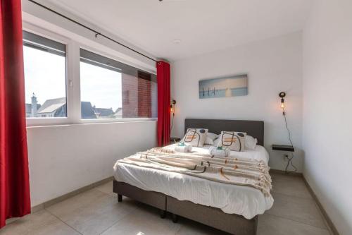 een slaapkamer met een bed en een raam bij Family-Friendly House with sunny terrace and garden in Oostende