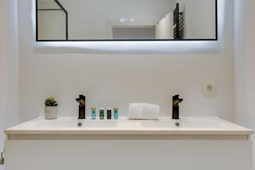 uma casa de banho com um lavatório branco e um espelho. em Stylish apartment with terrace and balcony em Antuérpia