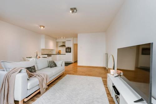 uma sala de estar com um sofá branco e uma cozinha em Stylish apartment with terrace and balcony em Antuérpia