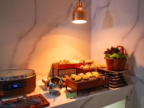 a buffet with bread and pastries on a table at L'Signature Hotel & Spa in Hanoi