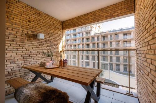 Huswell - Apartment with terrace close to the sea في أوستند: غرفة مع طاولة خشبية ونافذة كبيرة