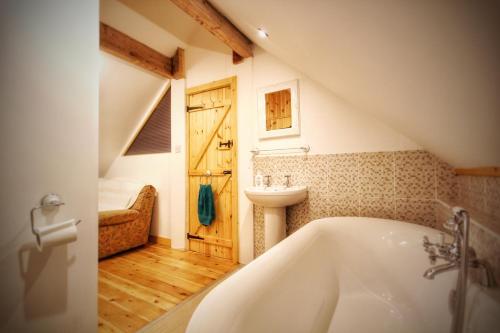 a bathroom with a bath tub and a sink at Y Boidy Bach Llangrannog in Llangranog