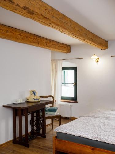 a bedroom with a bed and a table and a window at Płonica 1 in Złoty Stok