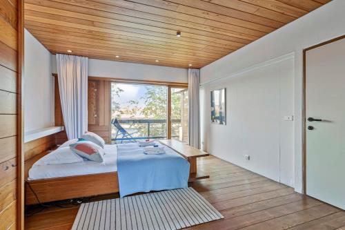 a bedroom with a bed and a wooden ceiling at Eighties modernist design house with garden near the beach in Ostend