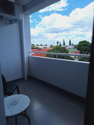 a room with a balcony with a table and a view at Sophisticated apartment in Maputo