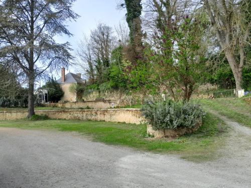 a street with a retaining wall and a house at Gîte Littérature dans le Perche in Rémalard en Perche