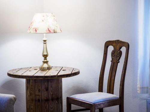 a table with a lamp and a chair next to a table with a lamp gmaxwell at Płonica 1 in Złoty Stok