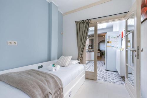 a bedroom with a white bed and a refrigerator at Spacious apartment with terrace in Ostend in Ostend
