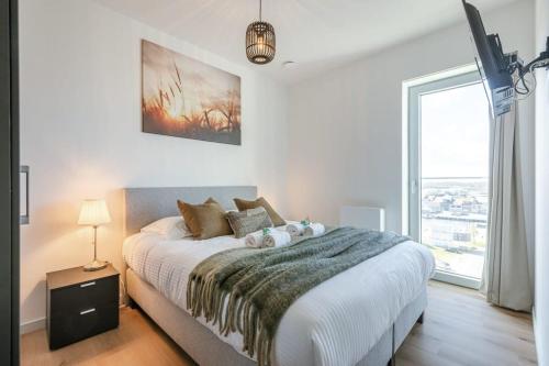 um quarto com uma cama grande e uma janela grande em Bright apartment with seaview em Bredene