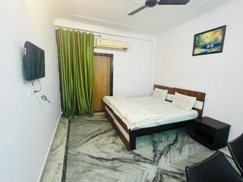 1 dormitorio con 1 cama y cortina verde en Hotel Saket Place - Near Saket Metro en Nueva Delhi