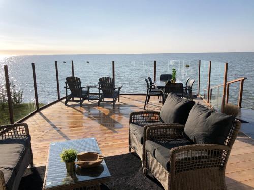 a deck with chairs and a couch and a table at Exclusieve vakantievilla ***** Markermeer in Bovenkarspel