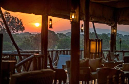 a view of the sunset from a restaurant with chairs at sunshine maasai Mara safari camp in Kenya in Sekenani