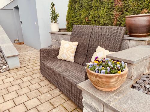 a wicker chair and a basket of flowers on a patio at Am Sonnenhang in Hilzingen